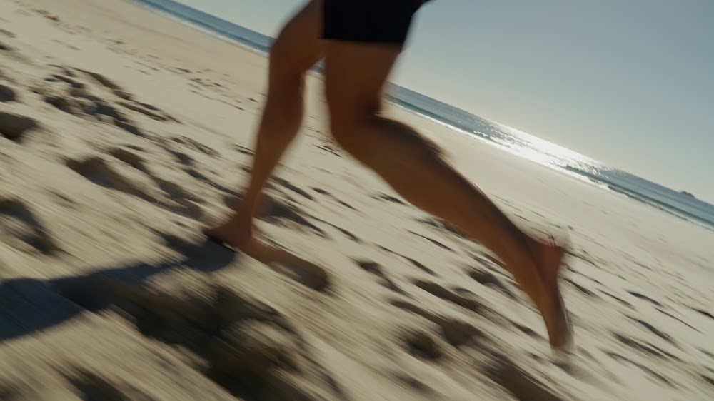 Running barefoot along the sand at first light